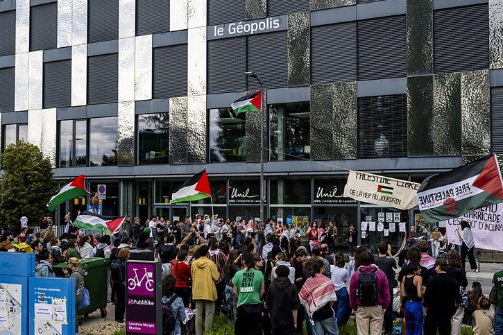 Environ 400 personnes ont écouté les prises de parole devant le bâtiment occupé. © KEYSTONE/JEAN-CHRISTOPHE BOTT